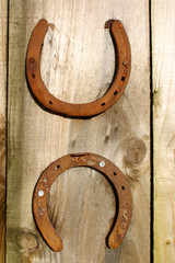 two horseshoes on a wooden background.
