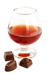 glass with cognac and sweets with liquor