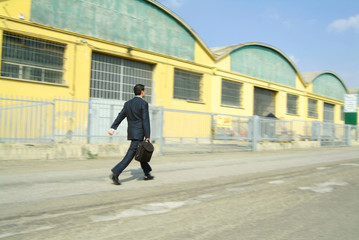 businessman walking in an industrial area