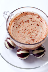 cup of cappucino and chocolate candies
