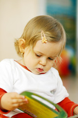 small baby reading a picture book