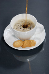 pouring coffee into a white coffee cup