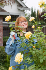 women cut roses in garden