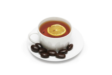 cup of tea with lemon and chocolates isolated on w