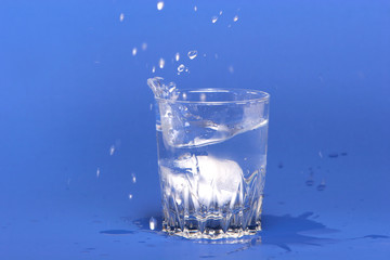 ice cubes thrown into glass of water