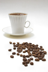 white cup of espresso with coffee beans