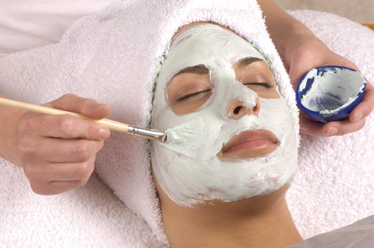spa esthetician applying facial masque