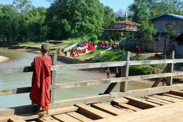 young monk on wooden bridge