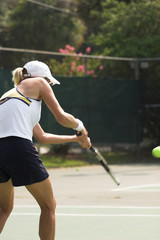 beautiful blonde woman returning tennis serve