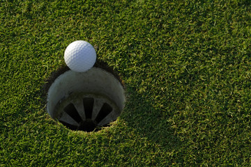 golfball an der kante des lochs
