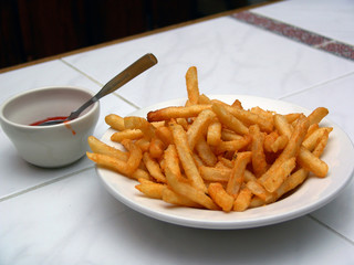 bowl of french fries and a cup of catsup
