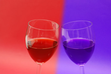 two wine glasses against the red background