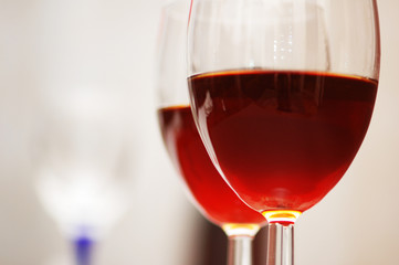 two wine glasses against the red background