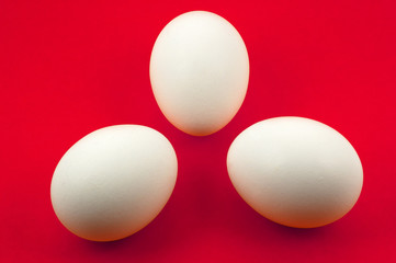 tree white eggs on red background