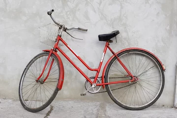 Foto op Plexiglas Fietsen oude rode fiets leunend tegen een muur