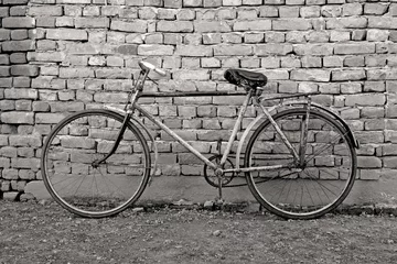 Tableaux ronds sur aluminium Vélo old bicycle leaning against a wall