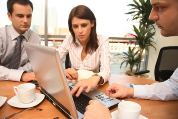 hree business persons  working together with lapto