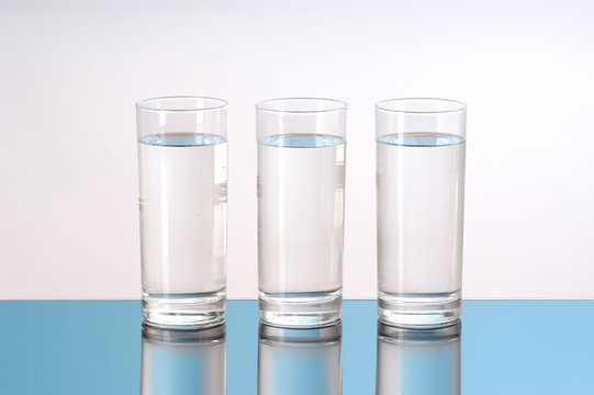 three glasses of water with reflection