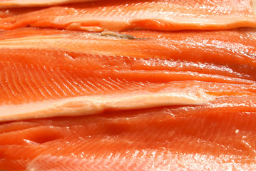 Fresh crude sliced trout filet background close-up.