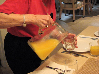 senior female pouring juice