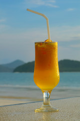 glass of juice against seascape