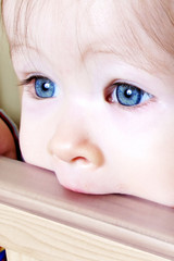 baby biting on crib - closeup