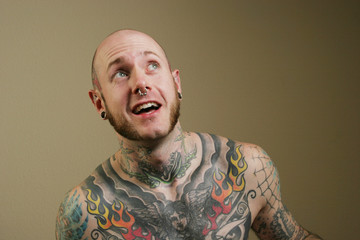 man with tattoos smiling