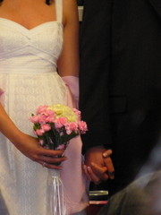 Obraz na płótnie Canvas bride and groom holding hands, while bride holds b