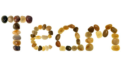 “team” in colored pebbles on an isolated white bac