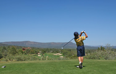 young golfer hitting a golf ball tee shot in the m