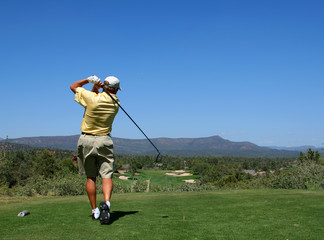 golfer driving golf ball on beautiful golf course