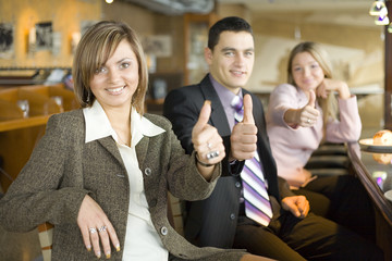 three of business people at coffee break - thumbs up