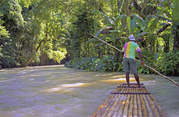 man on river raft jamaica