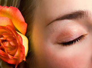 beautiful female closed eye and rose close-up