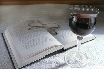 spectacles, book and wine glass