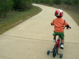 little boy learning to ride bicycle