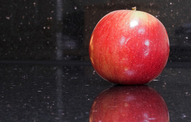 shiny red apple on granite