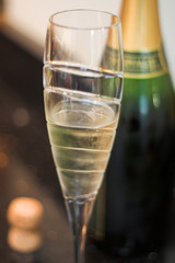 glass of champagne with opened bottle and cork