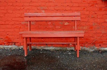 red bench at brick wall