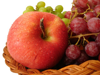 red apple and grapes in basket on white background