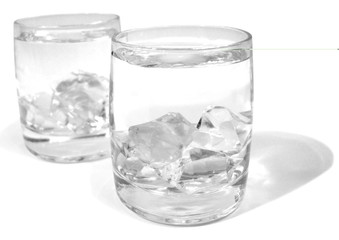 glass with water and ice over white