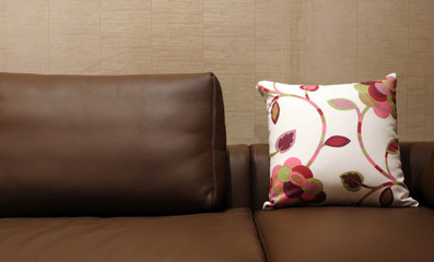 floral pillow on a brown leather couch