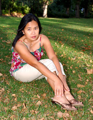 asian woman sitting on a lawn