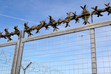 security perimeter fence with sharp spikes and bar