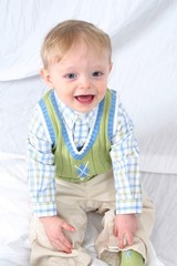 Fototapeta premium cute little boy sitting on white background.