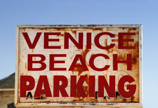 an old weathered venice beach parking sign