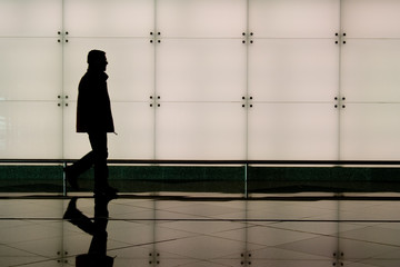 Plakat man walking through an airport terminal