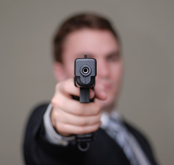 businessman points gun with shallow depth of field