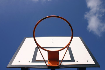 a rusty basketball hoop with a blue sky