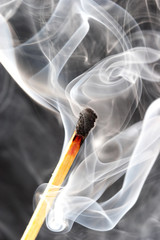 photo of a burning match in a smoke on a black background